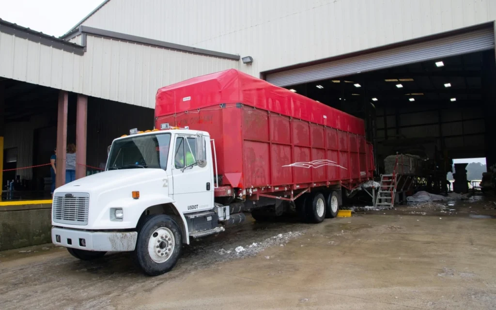 Carga de contenedores en camión desde puerto comercial